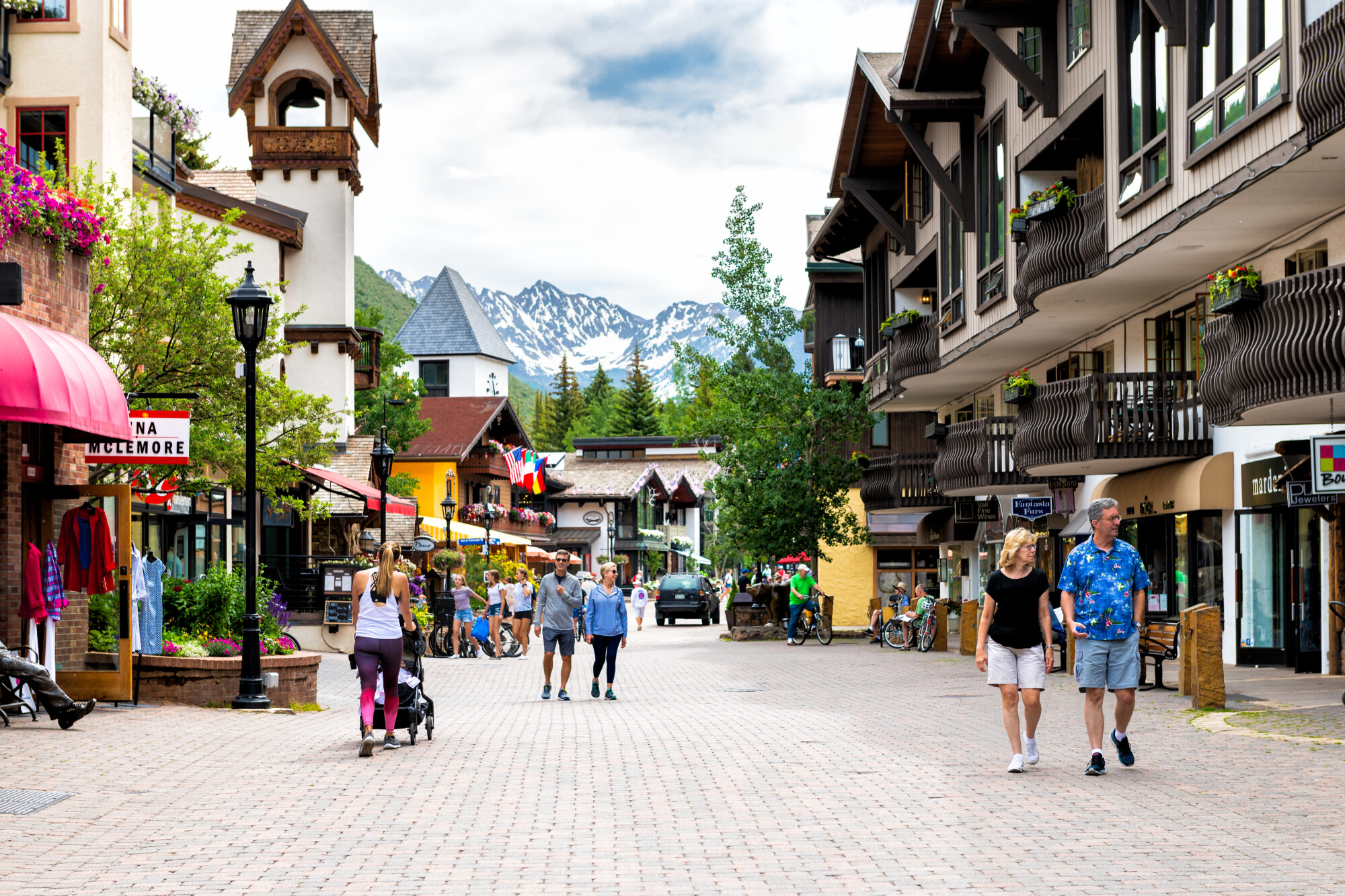 Vacation resort town of Vail, Colorado with people walking shopping by shops on Gore Creek drive