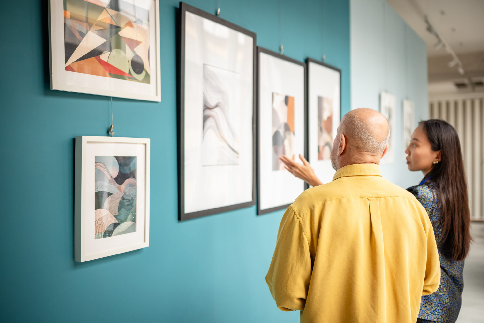 Two people discussing artworks in a contemporary art gallery exhibit